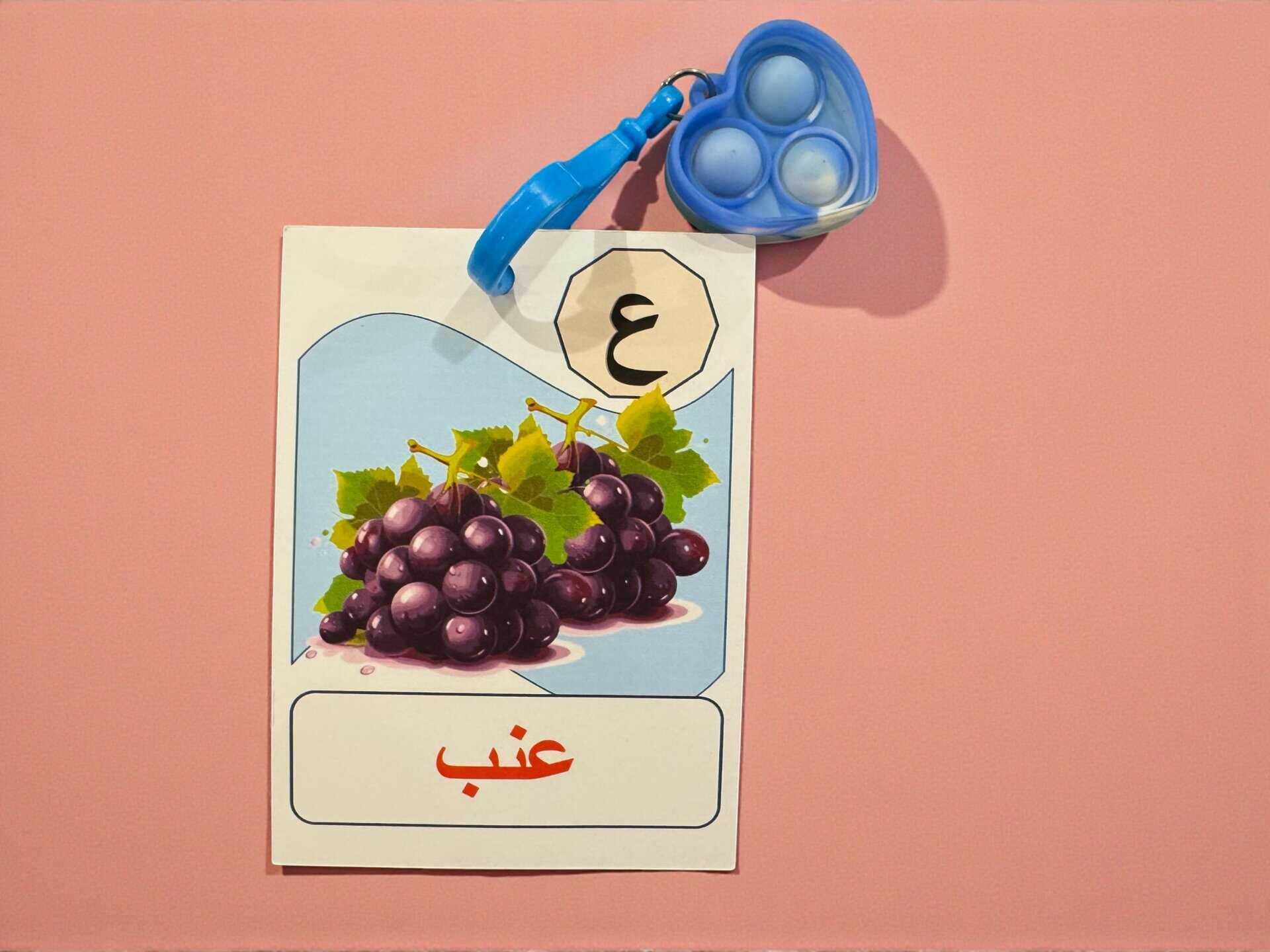 Letter Favor Card + Bubble Keychain 1 Arabic letter Ain favor card with grapes illustration and blue bubble keychain