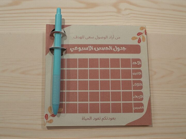 توزيعة الجدول مع قلم (حبر أزرق) وكرت وردي غامق 4 لقطة قريبة لكرت جدول الحصص مع مكان الإهداء